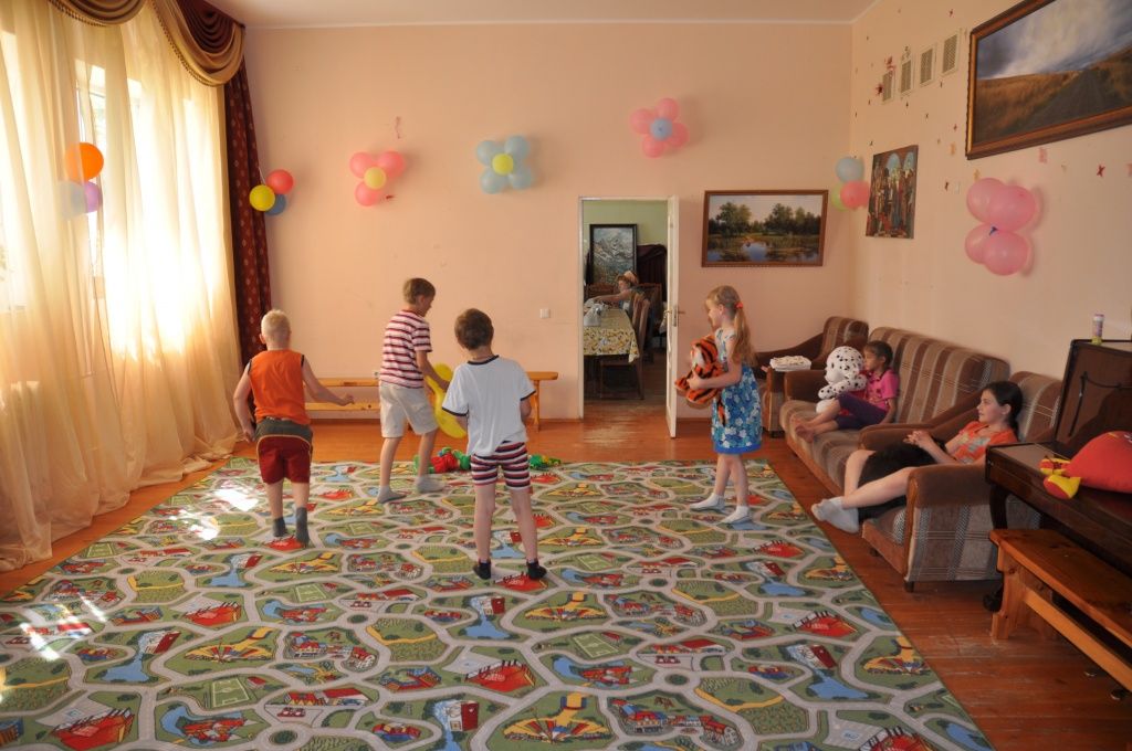 Дети из приюта играют на детском ковре